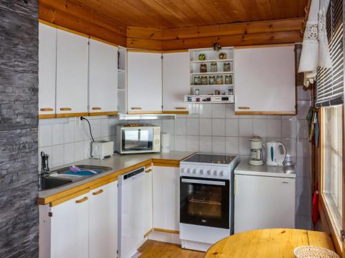 eine Küche mit weißen Geräten und einer Holzdecke in der Unterkunft Holiday Home Millantupa paritalo by Interhome in Hyrynsalmi