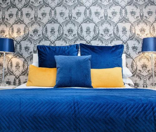 
a bed with a blue and white comforter and pillows at Killaran House in Killarney
