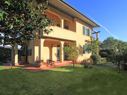 ein großes Haus mit einem Hof mit Gras und Bäumen in der Unterkunft Holiday Home Villa Anna by Interhome in Forte dei Marmi