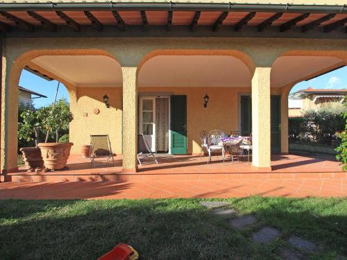 eine überdachte Terrasse mit einem Tisch und Stühlen in der Unterkunft Holiday Home Villa Anna by Interhome in Forte dei Marmi