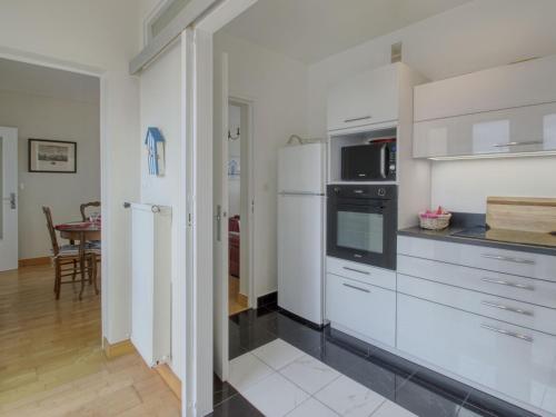 une cuisine avec des armoires blanches et un réfrigérateur blanc dans l'établissement Apartment Les Terrasses-2 by Interhome, à Saint-Malo
