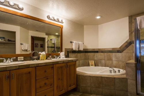 a bathroom with a tub and a sink and a mirror at Town Point Condos by Park City Vacations in Park City