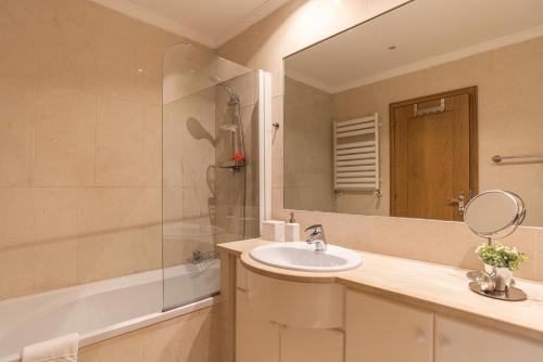 un bagno con un lavandino, uno specchio e una vasca di Porto Gaia RR Apartment by MP a Vila Nova de Gaia