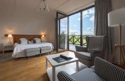 a hotel room with a bed and a balcony at Hotel SPA Dr Irena Eris Wzgórza Dylewskie - Siedliska in Wysoka Wieś