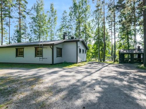 una casa blanca en medio de un bosque en Holiday Home Telkänkolo by Interhome, en Pertunmaa