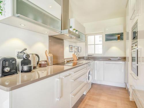 a kitchen with white cabinets and stainless steel appliances at Apartment Chalet Louisette by Interhome in Biarritz