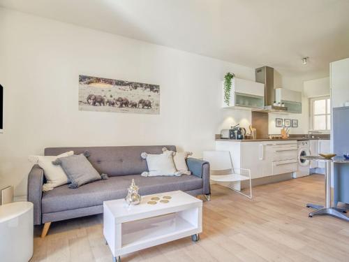 ein Wohnzimmer mit einem Sofa und einer Küche in der Unterkunft Apartment Chalet Louisette by Interhome in Biarritz