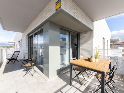 een patio met een houten tafel en stoelen op een balkon bij Apartment Alzina B by Interhome in Cambrils