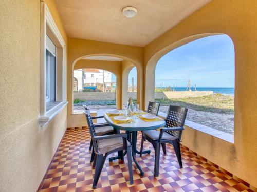 ein Esszimmer mit einem Tisch, Stühlen und Meerblick in der Unterkunft Holiday Home Casita Mar by Interhome in Denia
