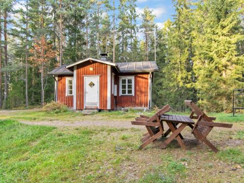 Cabaña de madera con mesa de picnic y banco en Holiday Home Santerin torppa by Interhome en Iitti