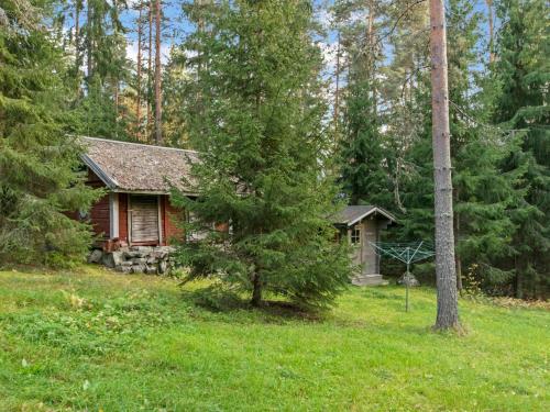 una cabaña de madera en el bosque con un árbol en el patio en Holiday Home Santerin torppa by Interhome en Iitti