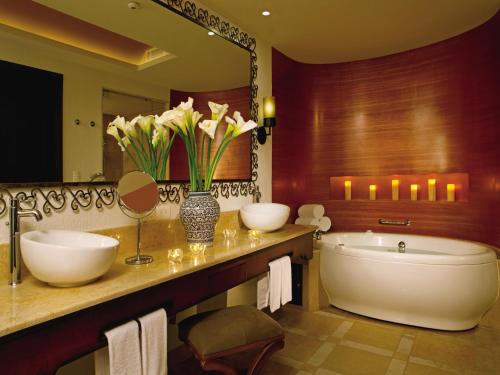 a bathroom with two sinks and a tub and a mirror at Secrets Puerto Los Cabos Golf & Spa18+ in San José del Cabo