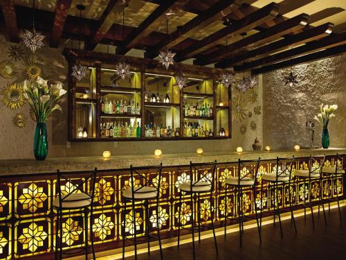 a bar with a bunch of chairs in a room at Secrets Puerto Los Cabos Golf & Spa18+ in San José del Cabo