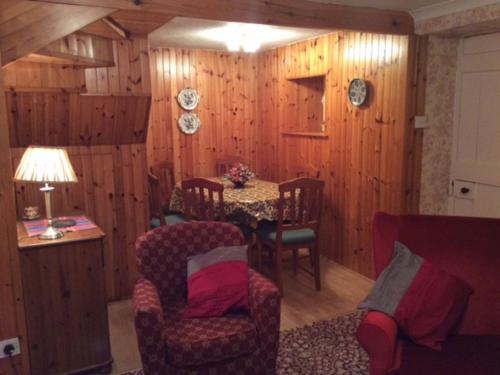 a dining room with a table and chairs and wooden walls at Holiday Home Leduckie by Interhome in Riechip