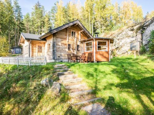 a log cabin in the woods with a path leading to it at Holiday Home Miilu by Interhome in Iitti