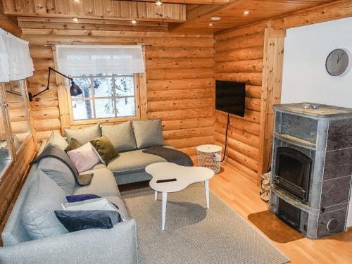 a living room with a couch and a fireplace at Holiday Home Lomapykälä 1 a by Interhome in Sirkka