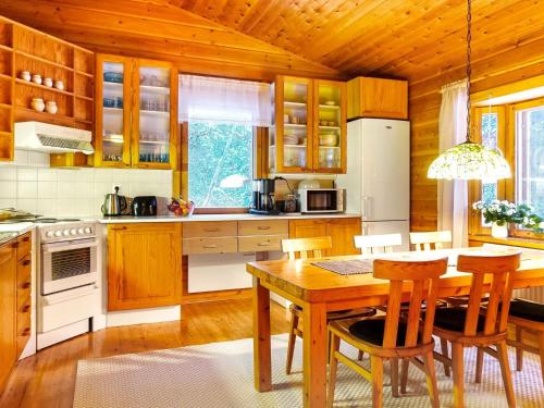 a kitchen with wooden cabinets and a table and chairs at Holiday Home Riekkotupa by Interhome in Enontekiö