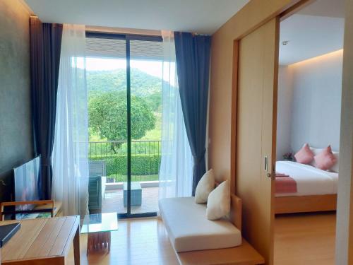 a bedroom with a bed and a large window at Zen Next Khao Yai By ZV in Pak Chong