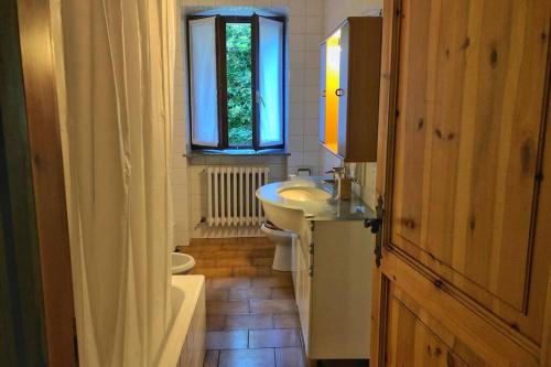 a bathroom with a sink and a toilet and a window at TRADITIONAL VILLA BELLAGIO san primo LAKE COMO in Bellagio