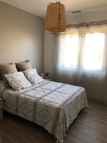 una camera da letto con un letto con un piumone bianco e due finestre di Villa Bergerac avec Piscine a Bergerac
