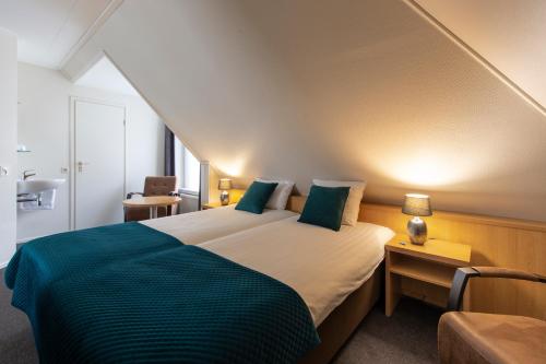 a bedroom with a large bed with green pillows at Hotel Restaurant Mondriaan in Winterswijk