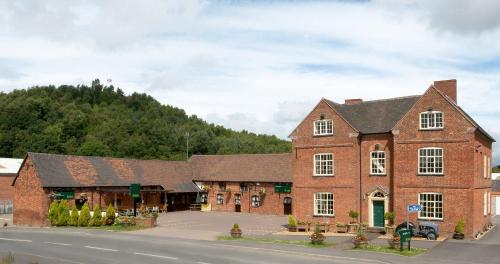 a large brick building on the side of a road at The Barns Hotel in Cannock