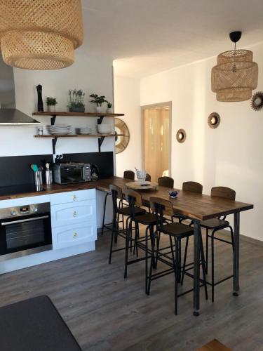 une cuisine avec une table en bois et quelques chaises dans l'établissement Villa Bergerac avec Piscine, à Bergerac