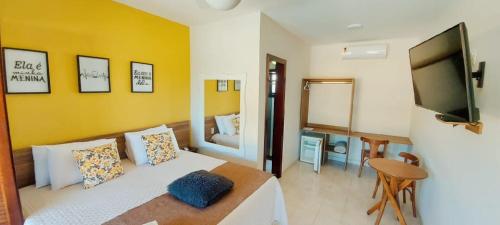 a bedroom with a bed and a flat screen tv at Pousada Algodão da Praia in Araruama