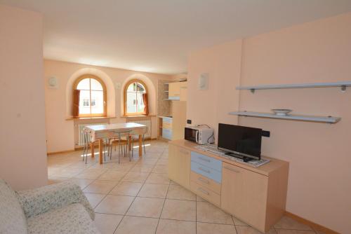 a kitchen with a couch and a table with a tv at Casa Fior del Soreie in Pozza di Fassa