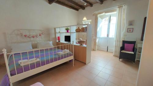 a bedroom with a bed and a desk and a chair at La Piazzetta in Siracusa