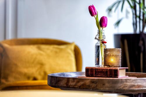 a vase with a flower in it on a table at Broeck Oudewater in Oudewater