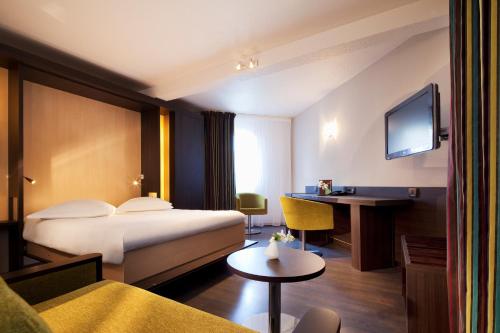 Habitación de hotel con cama y escritorio en Escale Oceania Vannes Centre, en Vannes