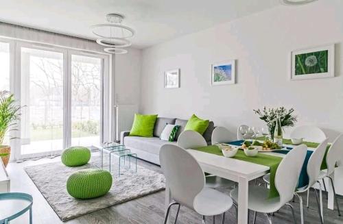 uma sala de estar com um sofá, uma mesa e cadeiras em Green Apartman Balatonlelle em Balatonlelle