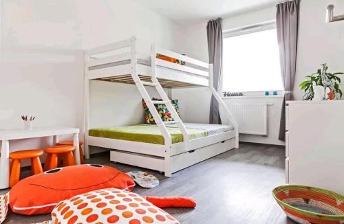 um quarto para crianças com um beliche e uma secretária em Green Apartman Balatonlelle em Balatonlelle