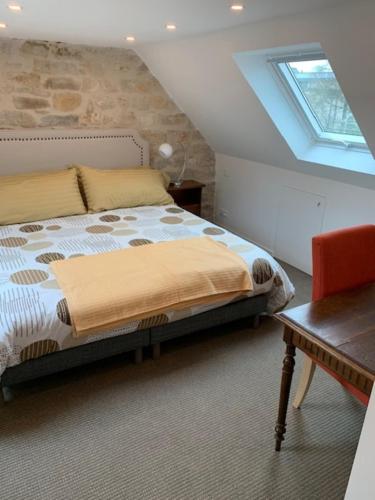 une chambre avec un lit, une table et une fenêtre dans l'établissement Brittany Vacation Rental, à Plomelin