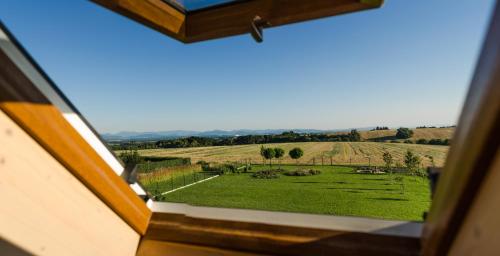 a view of a green field from a window at Penzion V Poli in Klimkovice