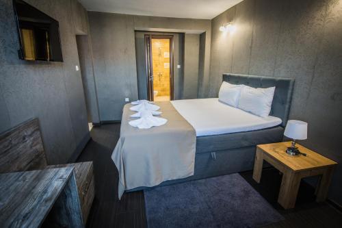 a small bedroom with a bed with towels on it at Vida Family Hotel in Vidin