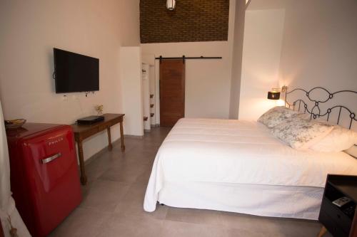 a bedroom with a large white bed and a television at Pousada Vila Nakau in Fernando de Noronha