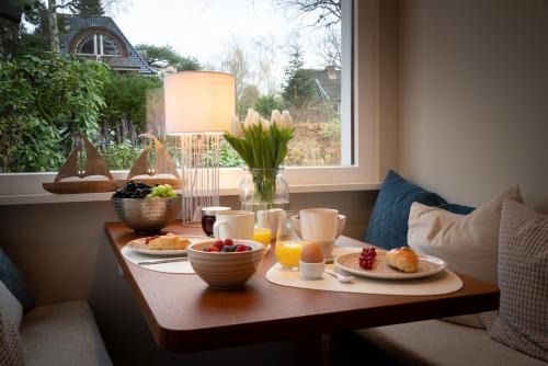 a table with breakfast food on it with a window at Studio-Apartment Piccolino 26 in Timmendorfer Strand