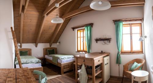 a room with two beds and a desk in a house at Penzion V Poli in Klimkovice