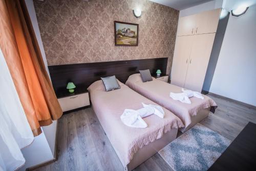 a bedroom with two beds with towels on them at Vida Family Hotel in Vidin