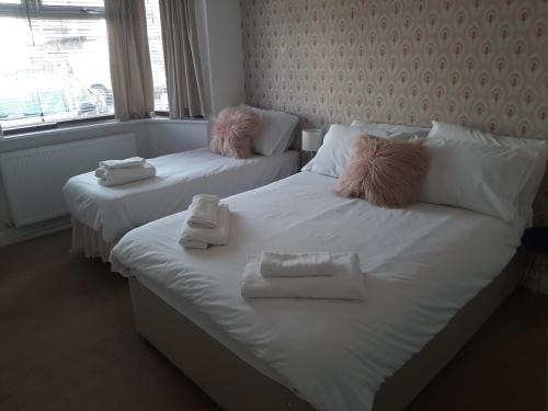 two beds in a room with towels on them at Home from Home Stay Margate in Margate