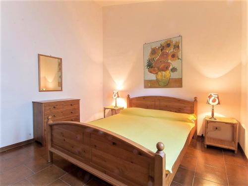 a bedroom with a wooden bed and two lamps at Ampio bilocale nel centro storico Castiglione della Pescaia in Castiglione della Pescaia