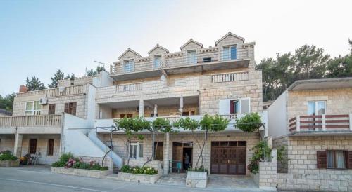 un grande edificio in mattoni con balconi in cima di House Povlja (3365) a Povlja