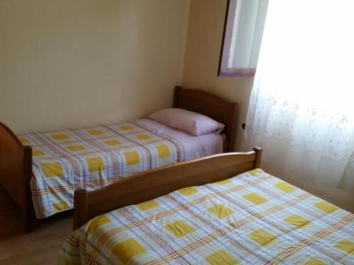 a bedroom with two beds and a window at Apartment Basina (3450-2) in Stari Grad