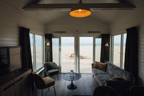 een woonkamer met een bank en een tafel bij Logeren aan Zee in Katwijk aan Zee