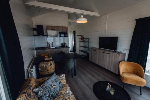 a living room with a couch and a table at Logeren aan Zee in Katwijk aan Zee