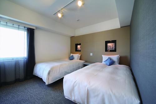 札幌的住宿－札幌大通維斯塔酒店，酒店客房设有两张床和窗户。