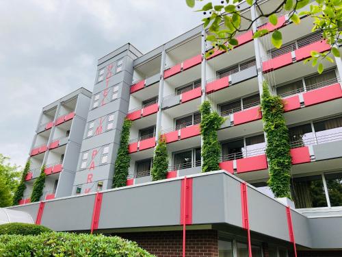 un edificio de apartamentos con plantas en los balcones en Hotel im Park, en Bad Iburg