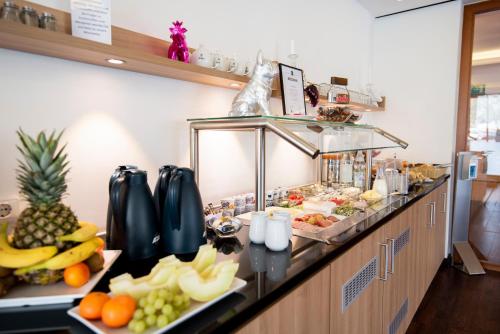 a buffet line with fruits and vegetables on a counter at Hotel im Park in Bad Iburg